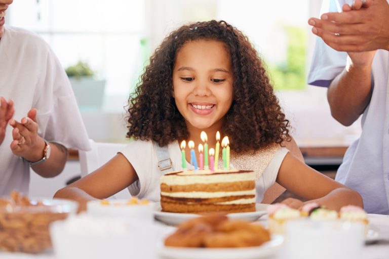 Little girl, birthday and candle cake for wish in party celebration for child in happiness at home.