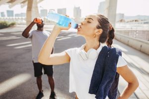 Sporty runners couple drinking energy drink after running