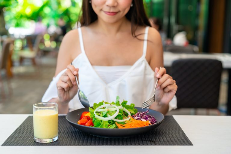 Young woman eating healthy salad at restaurant, Healthy lifestyle and diet concept